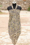 Handblock printed cotton sarong with tribal and geometric motifs in mustard, blue, and black, displayed on a mannequin outdoors.