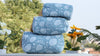Stack of blue patterned pillows with a blurred natural background