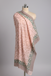 Pink floral patterned sarong on a mannequin against a gray background