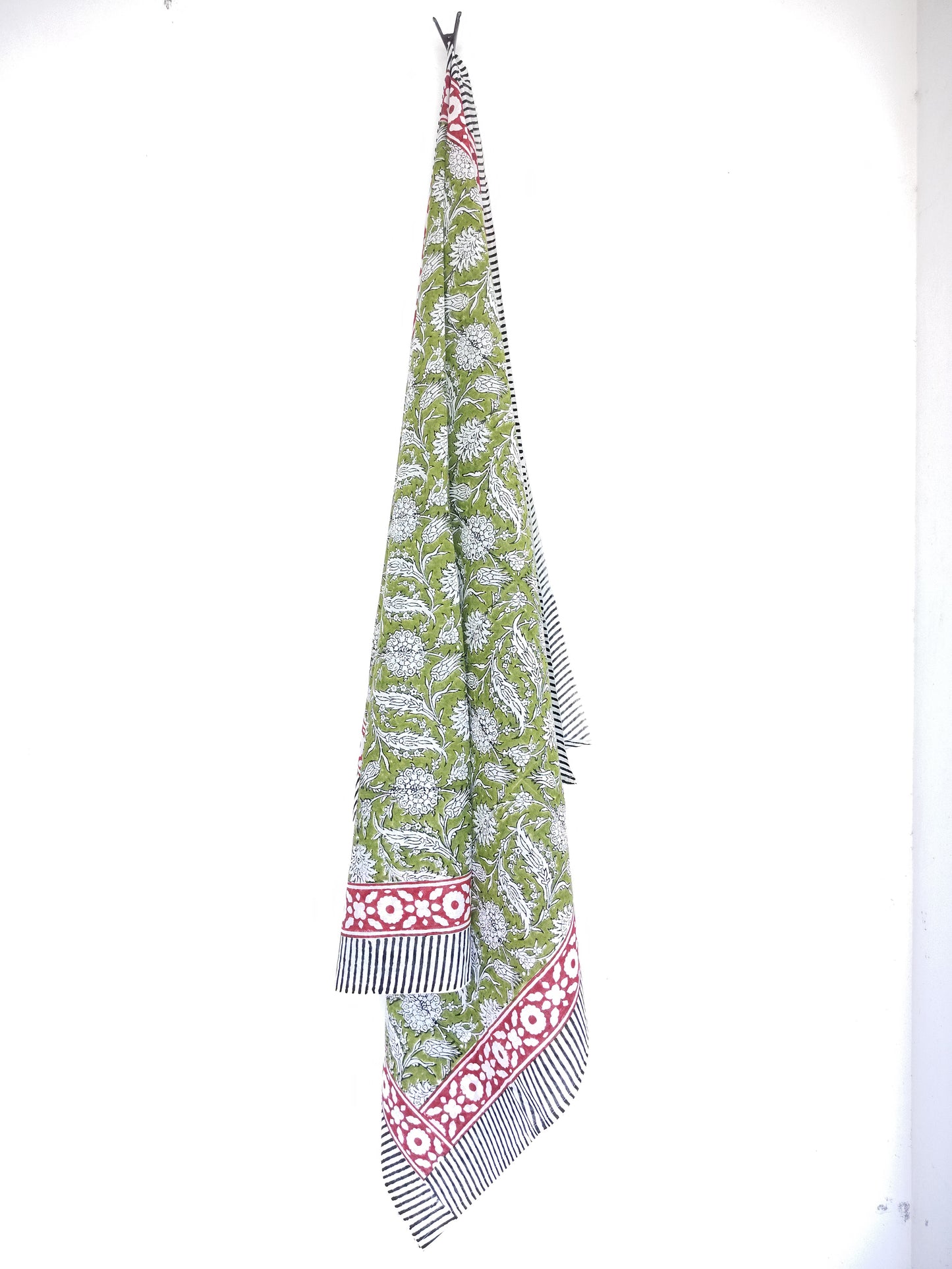 Long, patterned sarong with green base and red and white accents on a white background