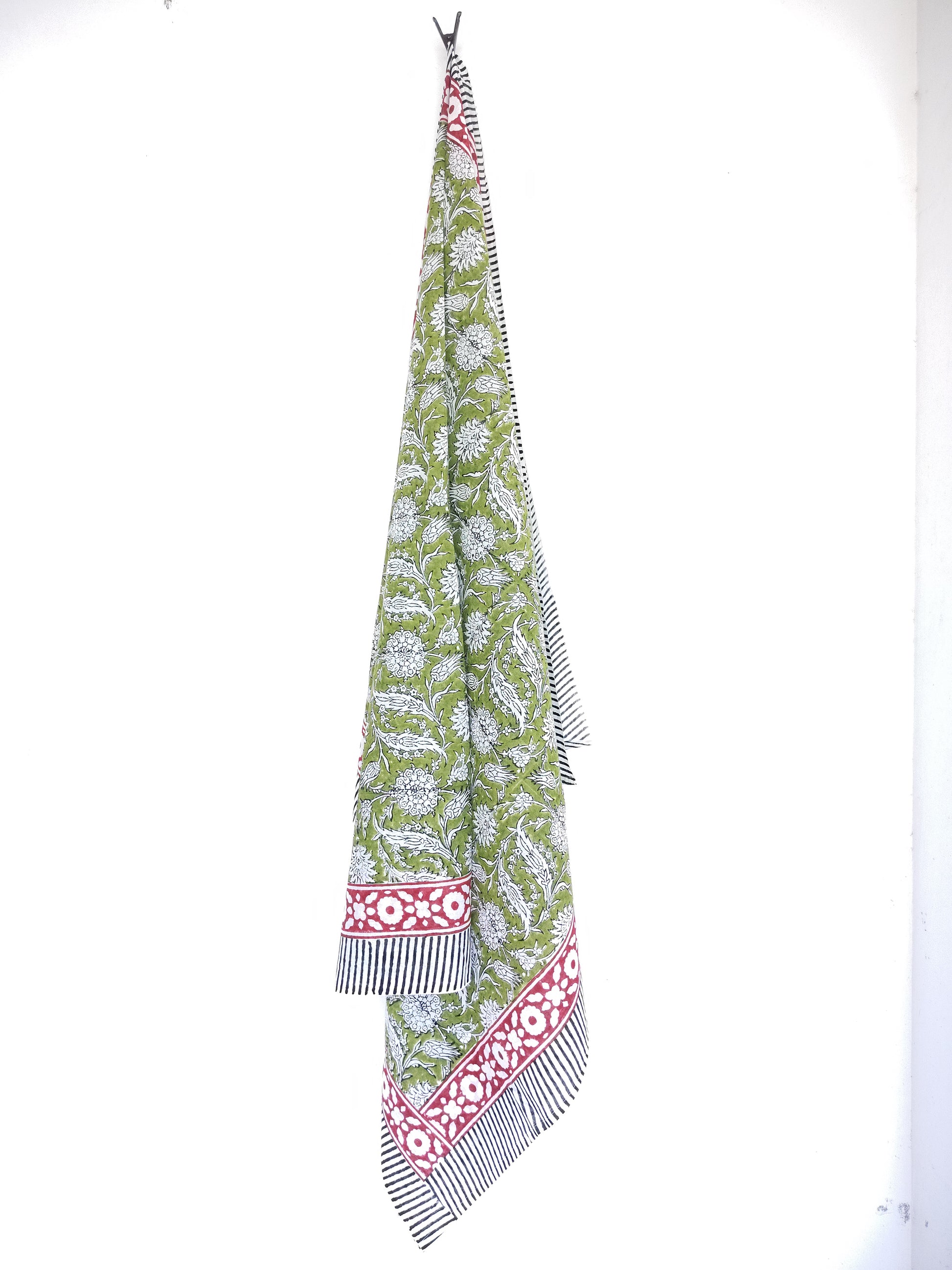 Long, patterned sarong with green base and red and white accents on a white background