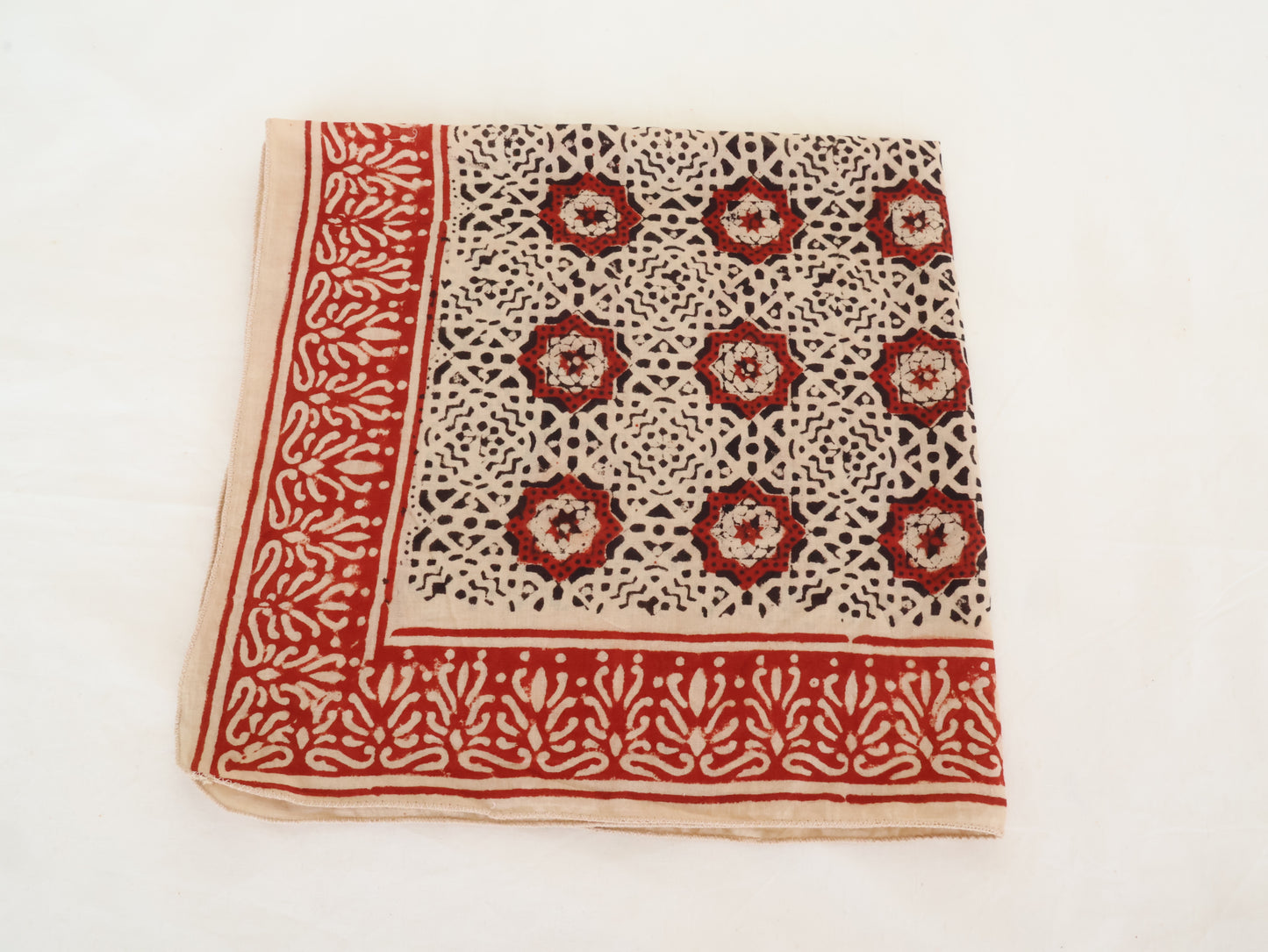 Fabric with red and black floral pattern on a white background