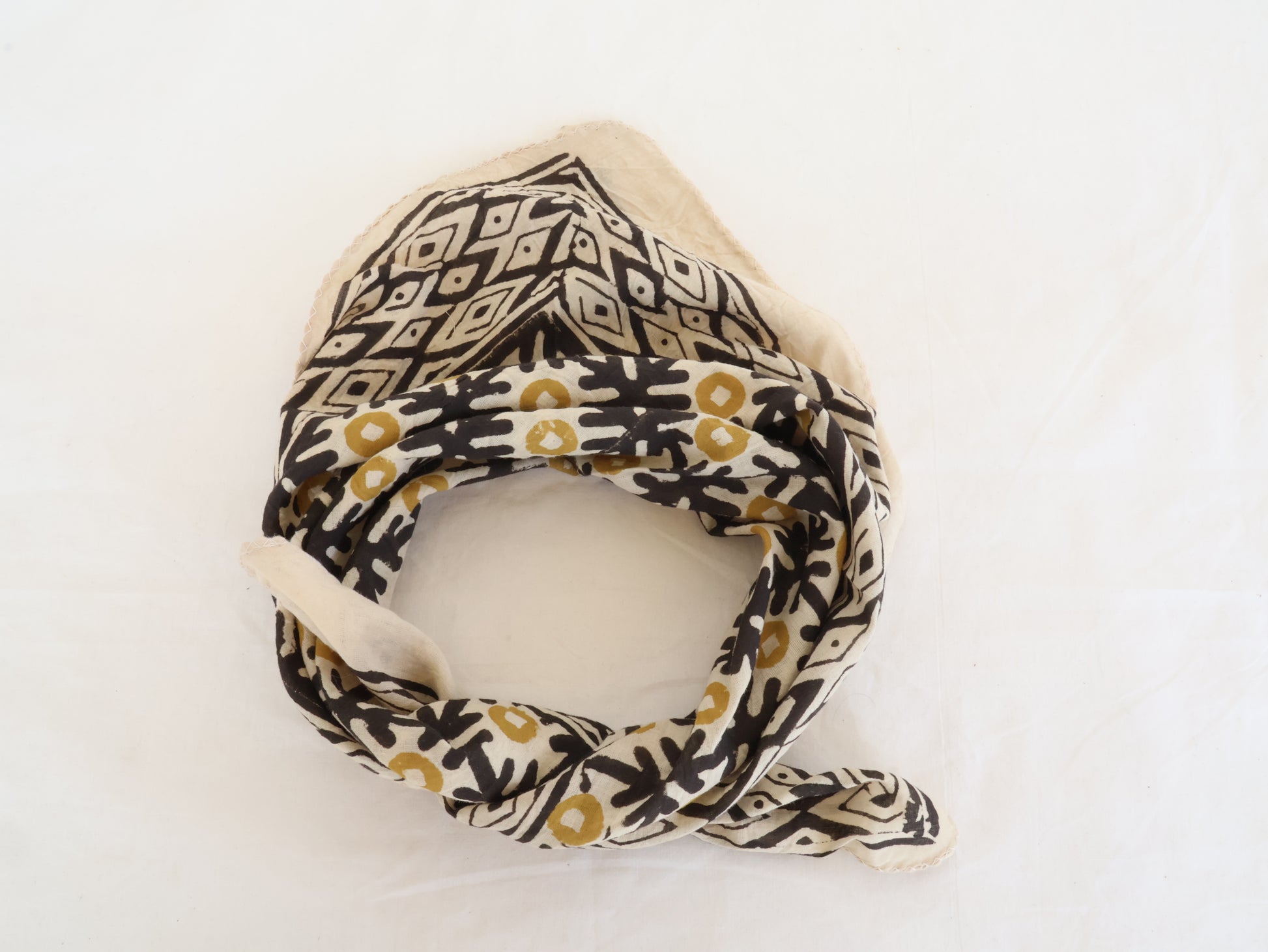 Neck scarf with geometric and floral patterns on a white background