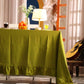 Green tablecloth on a table with decorative items in a room with a guitar and floral decorations.