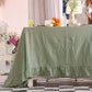 sage Green tablecloth on a table with decorative items in the background