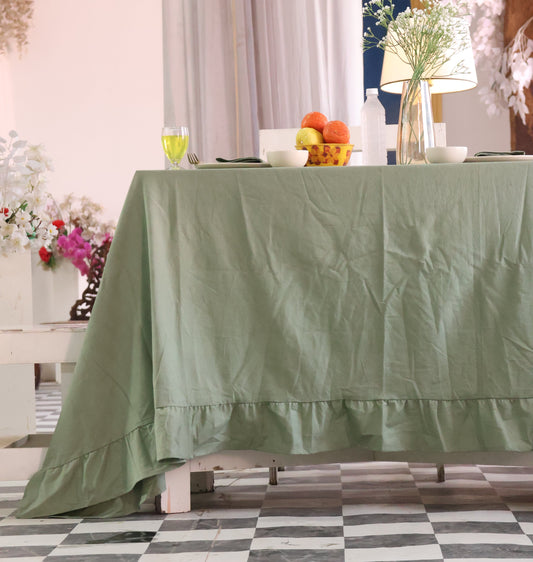 sage Green tablecloth on a table with decorative items in the background