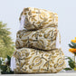 Stack of patterned pillows with flowers in the background