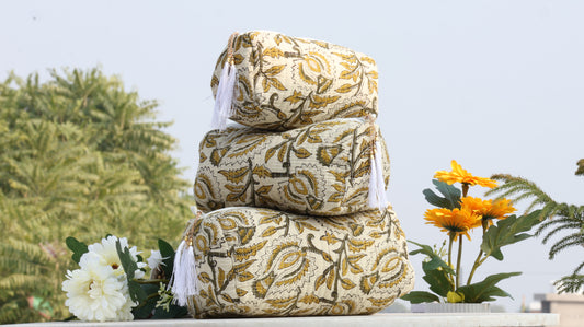 Stack of patterned pillows with flowers in the background