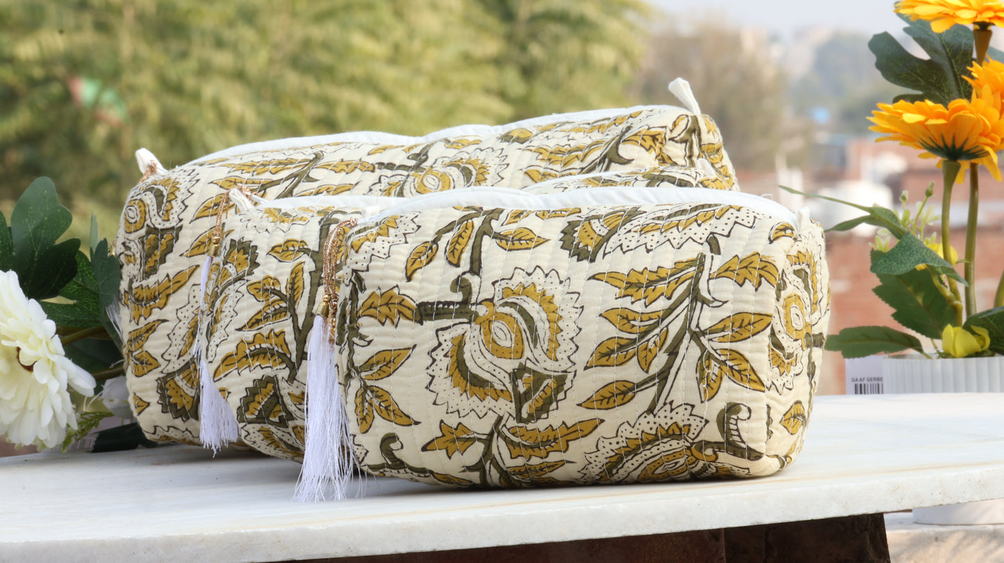 Floral-patterned bag with tassels on a surface with flowers in the background