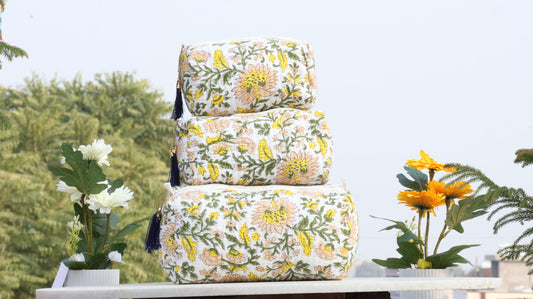 Stack of floral-patterned bags on a table with plants in the background