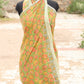 Green and orange patterned fabric on a mannequin against a blurred natural background