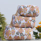Stack of floral-patterned towels with plants in the background