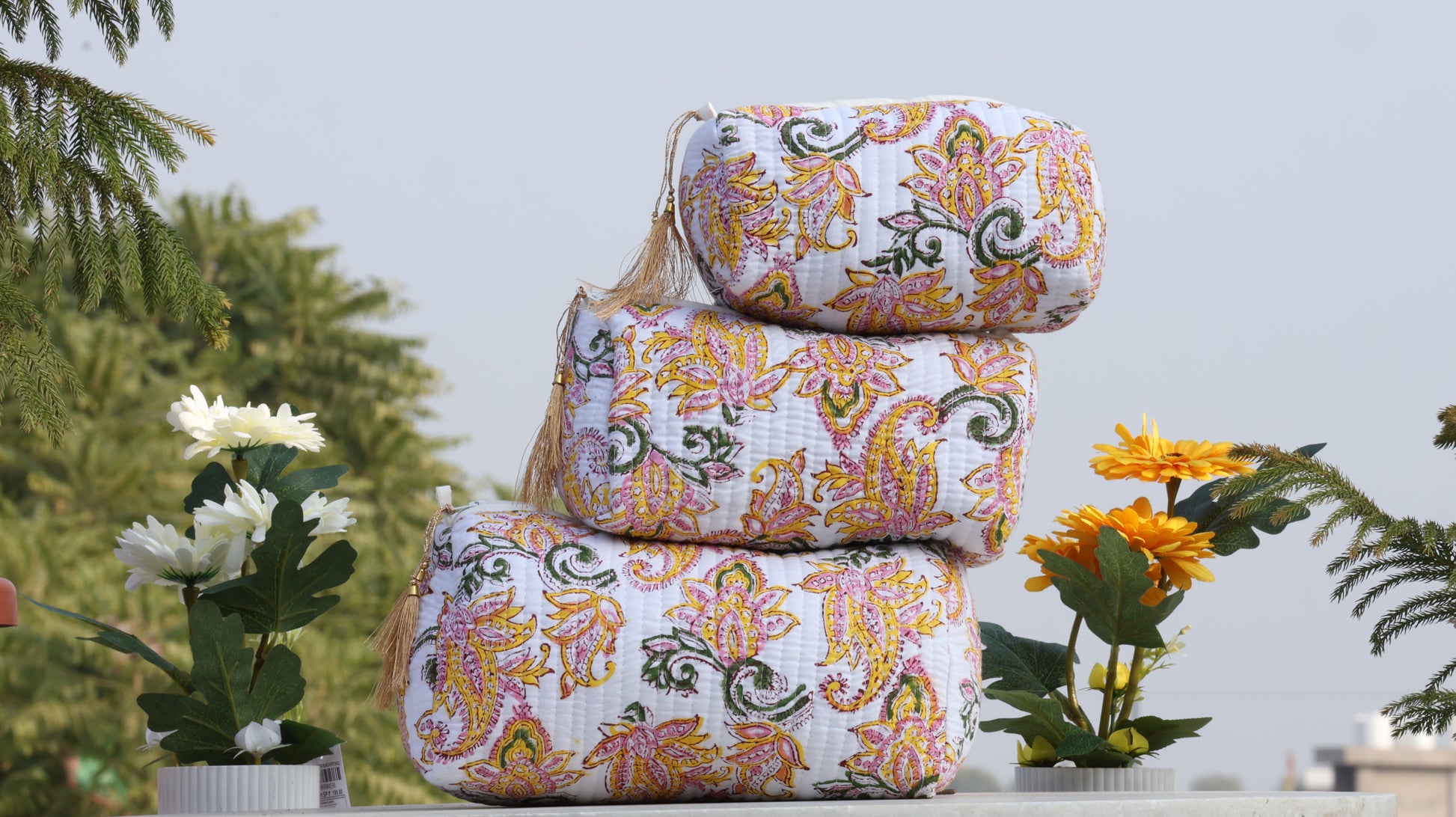 Stack of floral-patterned towels with plants in the background
