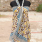 Handblock printed cotton sarong draped on a mannequin, featuring yellow floral motifs, a blue decorative border