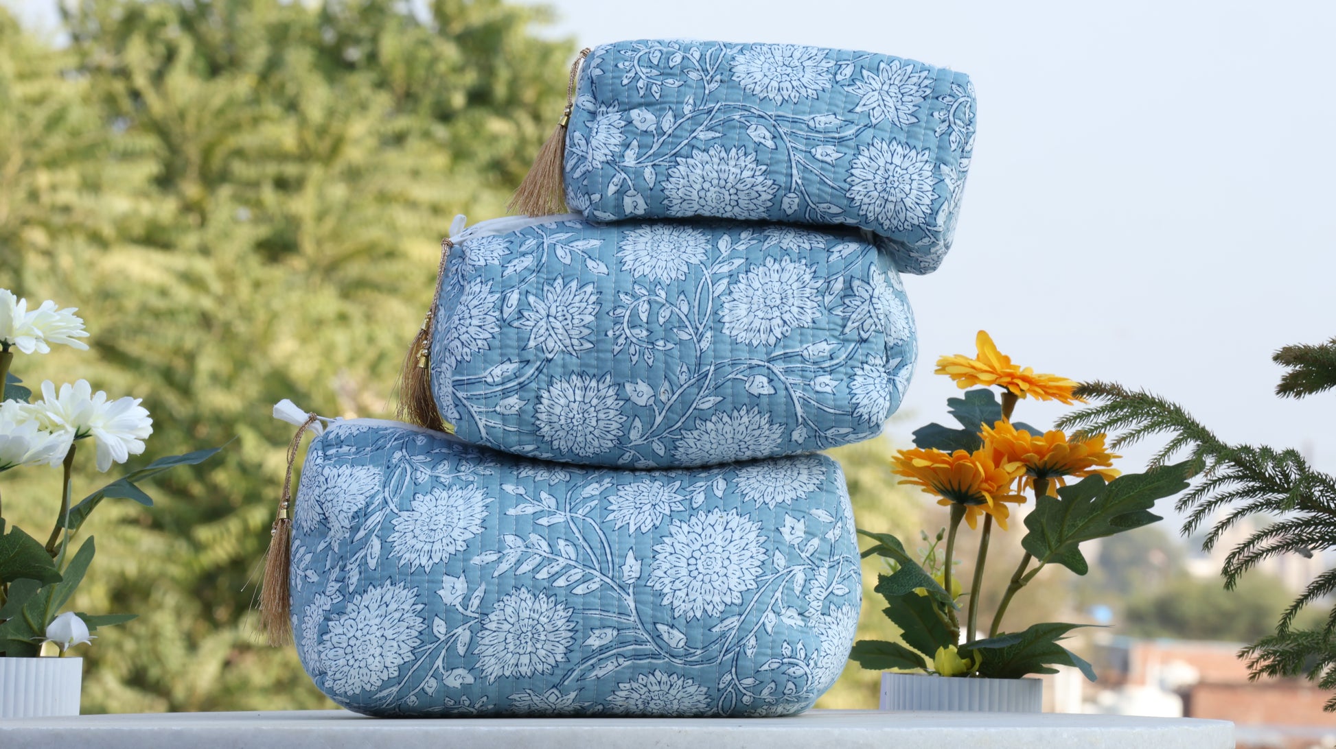 Stack of blue patterned pillows with a blurred natural background