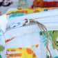 Colorful fabric pouch with a zipper and decorative string, featuring animal prints.
