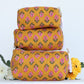 Stack of three yellow floral-patterned makeup bags with a white background