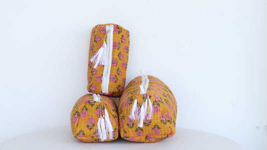 Three yellow fabric storage boxes with floral patterns on a white background