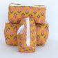 Yellow fabric bags with pink floral pattern on a white background