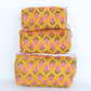 Set of three yellow fabric bags with pink floral patterns on a white background