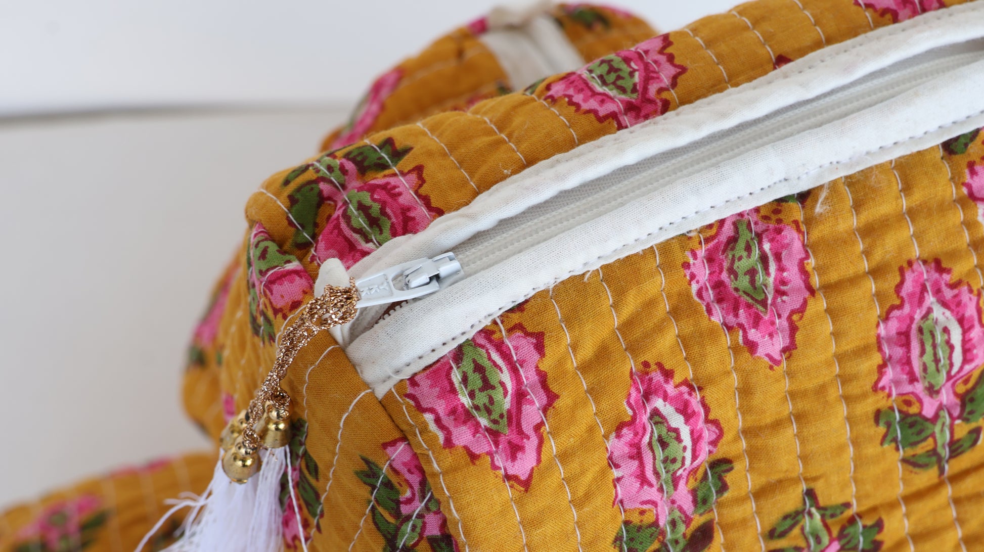 Close-up of a floral-patterned fabric bag with a zipper.