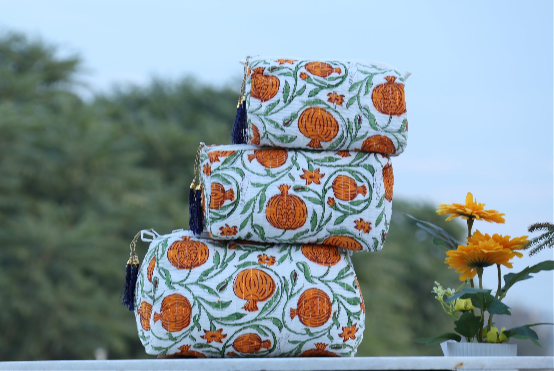 Set of three patterned bags on a table with a blurred natural background