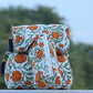 Decorative bag with orange floral pattern on a blurred natural background
