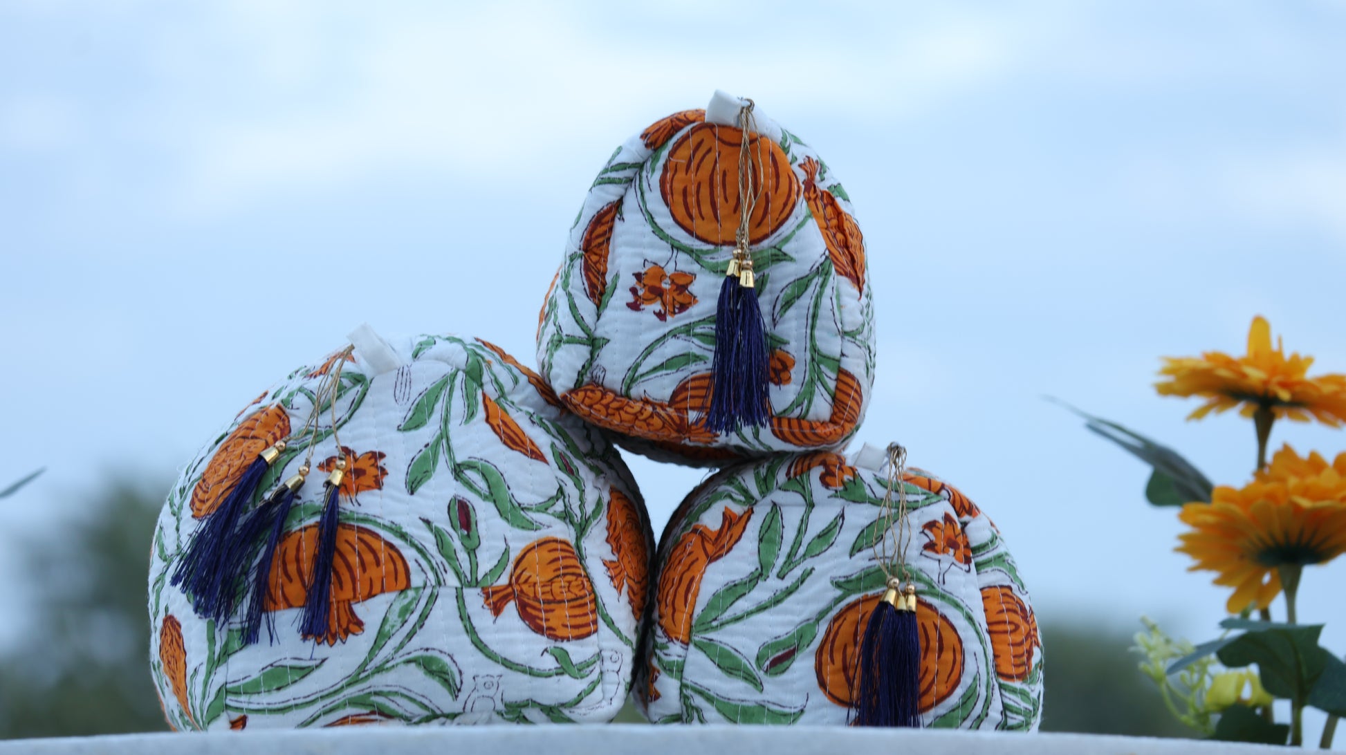 Decorative boxes with floral patterns and tassels on a blurred natural background