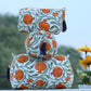 Decorative bags with orange floral patterns on a blurred natural background