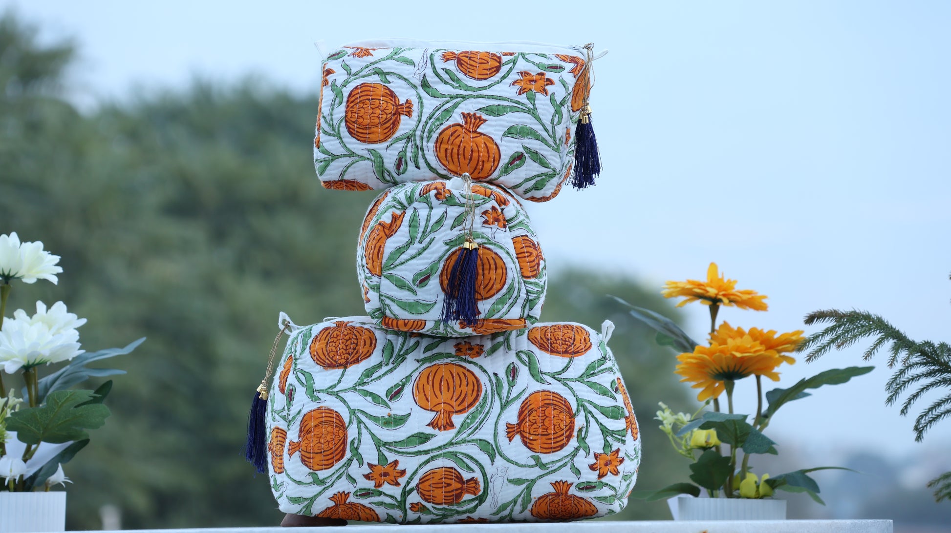 Decorative bags with orange floral patterns on a blurred natural background