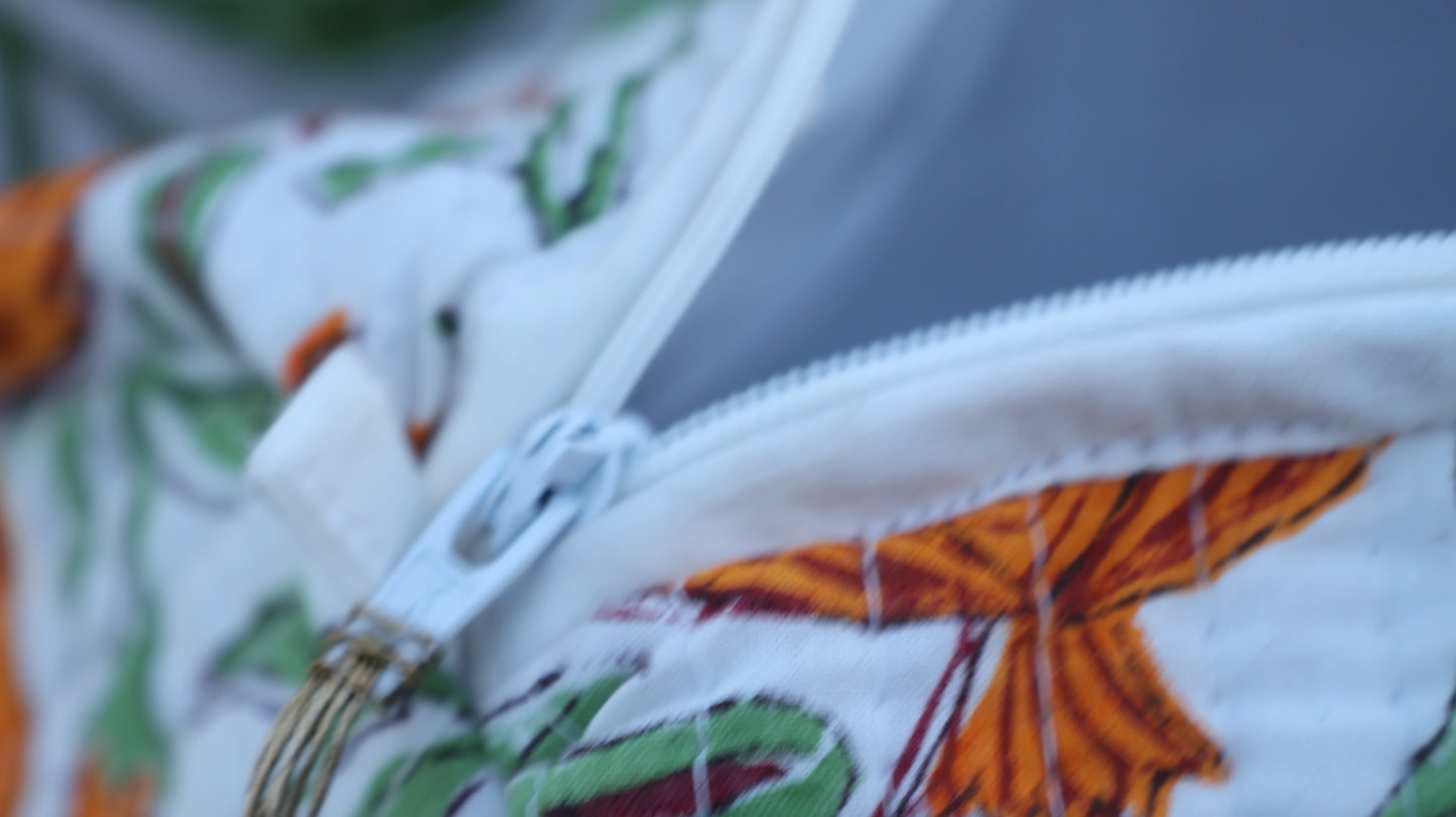 Close-up of a zipper on a fabric with colorful patterns, including green and orange elements.