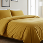 Yellow bedding set on a bed in a well-lit bedroom